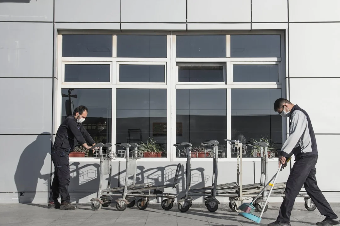 Covered with sheet sofa and floor lamp and packed cardboard boxes in light spacious room of new contemporary house